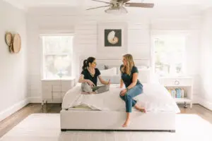 Blog 6 Two baby proofers sitting on a bed, discussing safety principles.