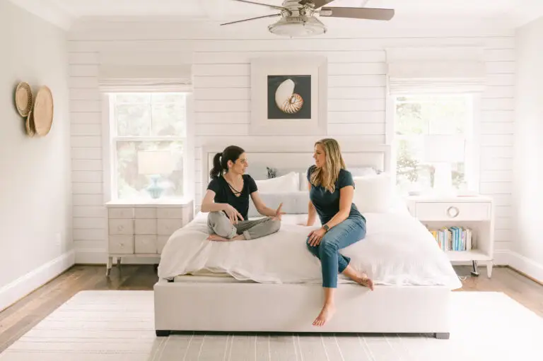 Two baby proofers sitting on a bed, discussing safety principles.